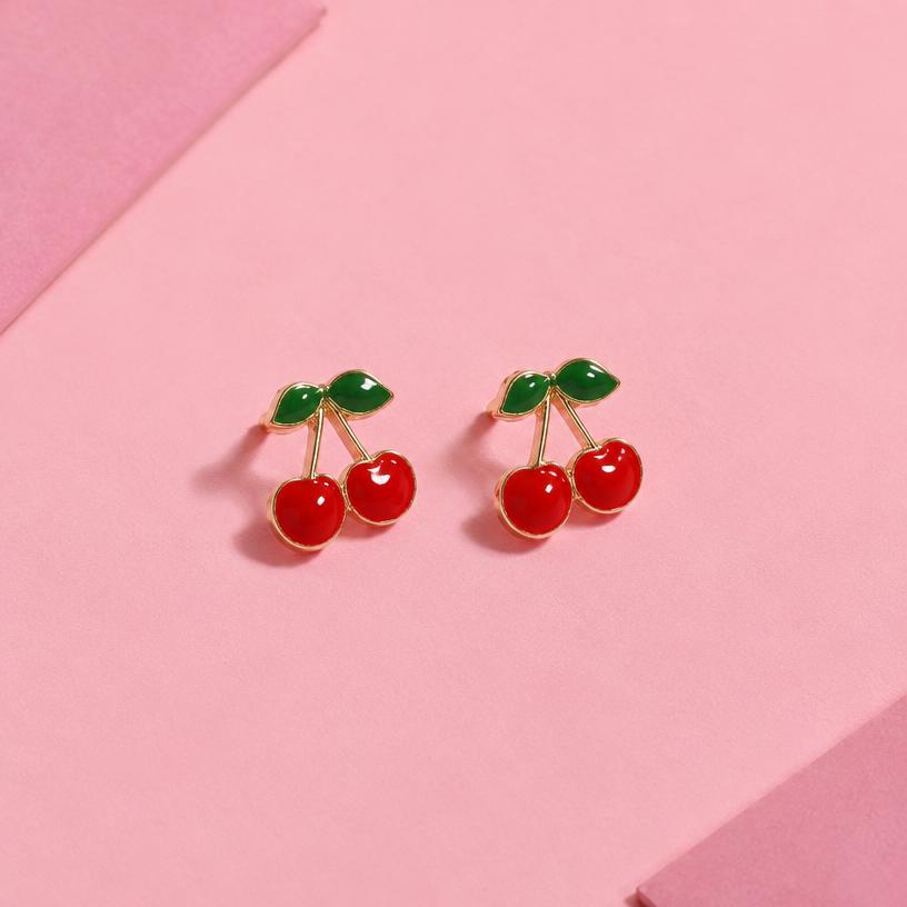 Red cherry enamel stud earrings on pink paper