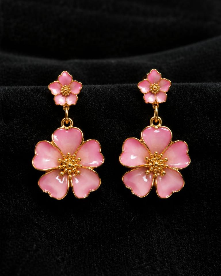 Pink enamel flower drop earrings on black velvet